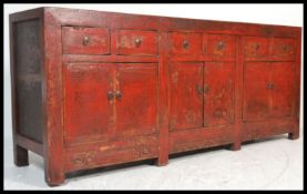 A large Chinese red lacquered sideboard o long form six drawers above three cupboards with Greek key