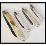 A group of four mother of pearl handled fruit pen knives to include three silver hallmarked examples