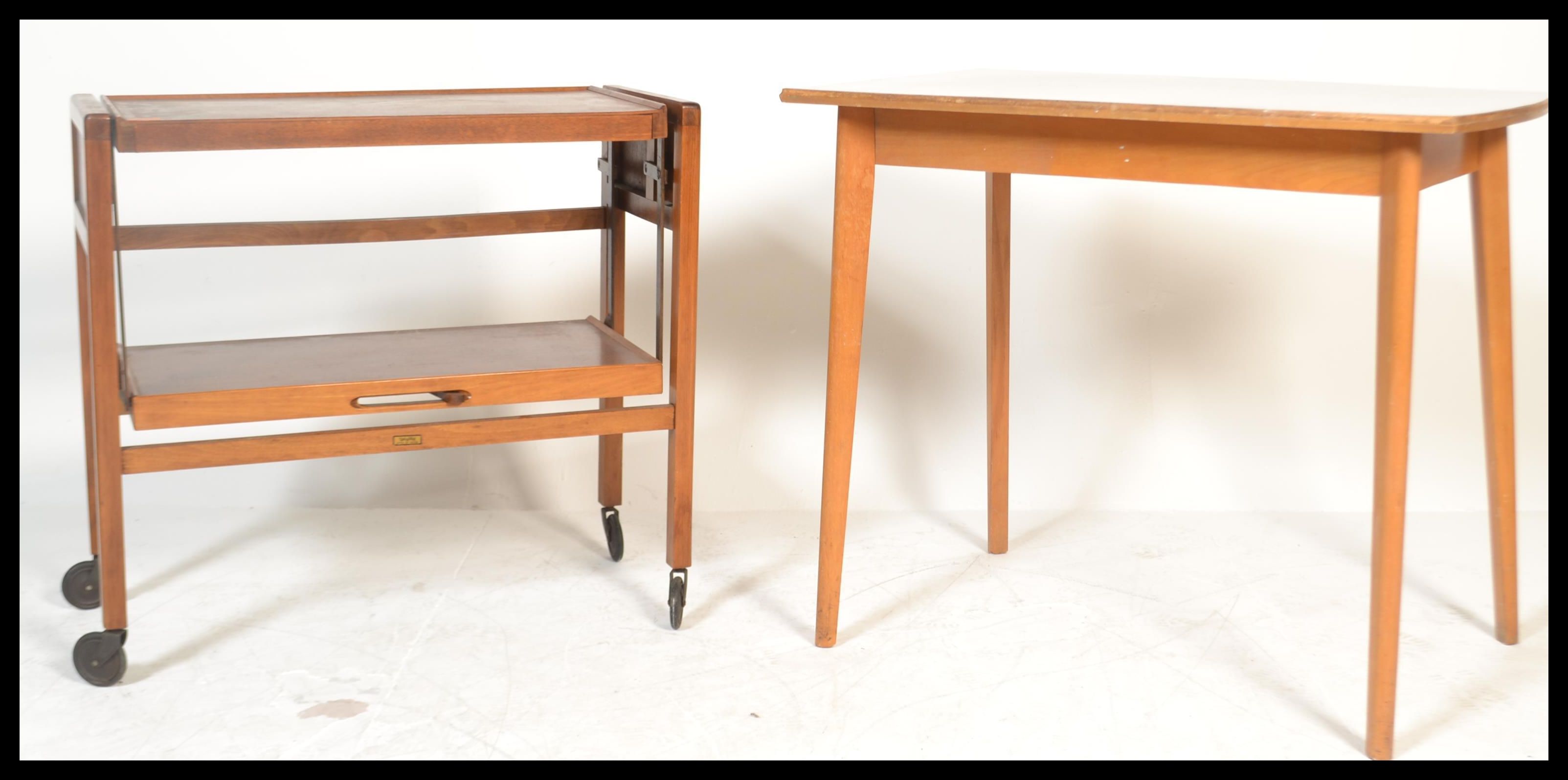 A vintage mid 20th Century teak wood metamorphic buffet trolley raised on square supports on castors