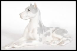 A vintage 20th Century USSR ceramic figurine of a great dane modelled in a reclined position but