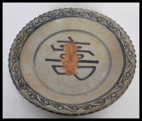 A 20th Century Chinese ceramic charger plate bowl having a scalloped edge with blue concentric