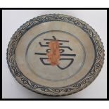 A 20th Century Chinese ceramic charger plate bowl having a scalloped edge with blue concentric