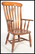 A Victorian 19th century beech and elm wood windsor chair / armchair being raised on turned legs