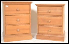 A pair of antique style country pine bedside cabinets raised on plinth bases. The straight bank of