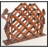 A vintage 20th Century large multi section hard wood wine rack mounted on plinth base flanked by