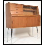 A retro 20th Century teak wood highboard - sideboard having an arrangement of drawers with fall