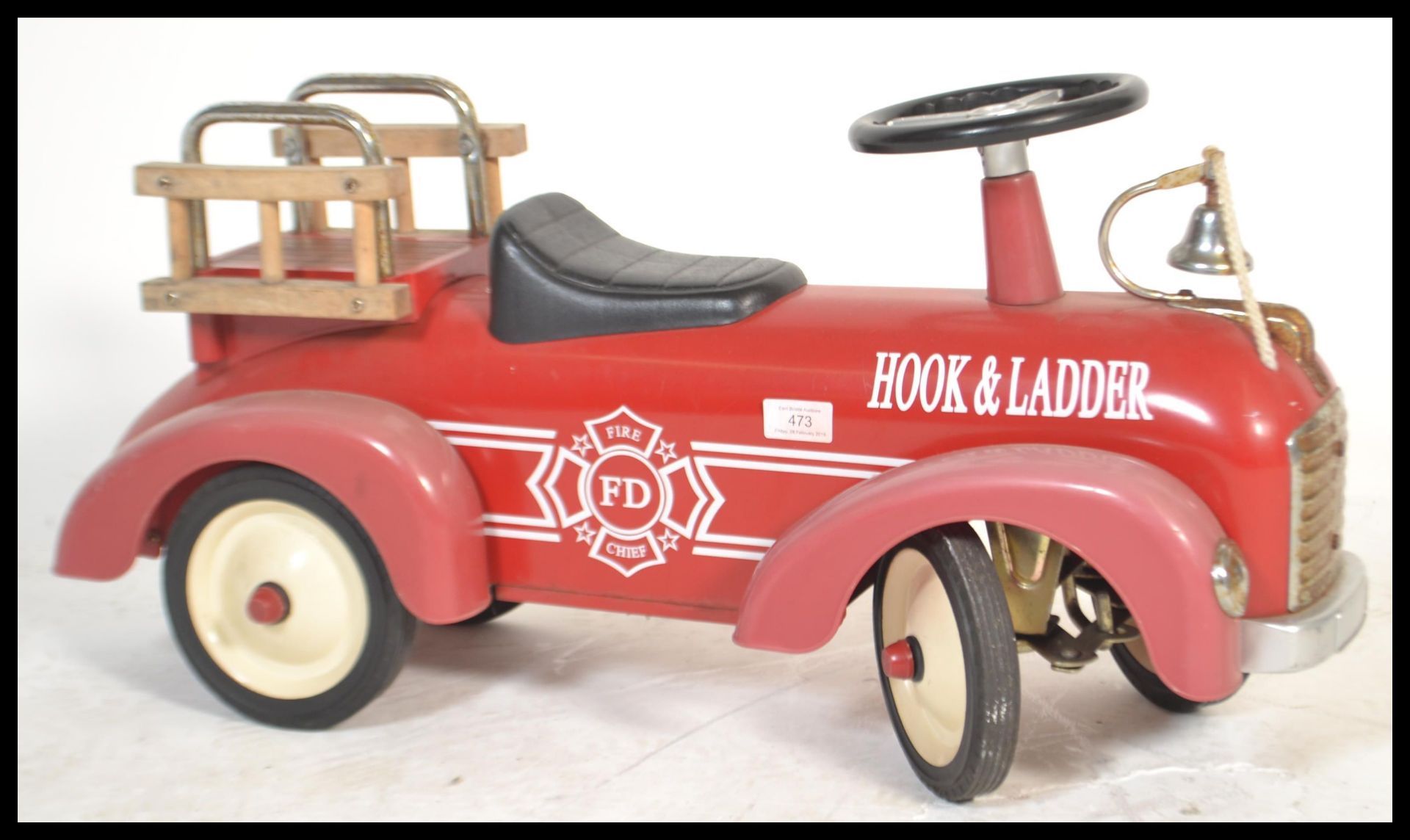 A children's fire ride along truck toy in the form of a fire truck reading 'Hook and Ladder' of