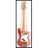 A vintage Marlin electric stratocaster style bass guitar having a red body with chrome tuning