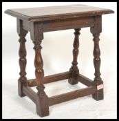 An early 20th Century oak peg jointed stool raised on block and turned legs with carved details.
