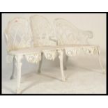 A Coalbrookdale style cast iron three seater white painted garden bench having foliate decoration