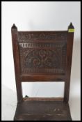 A 17th Century oak carved back stool. The chair raised on turned and block stretchered legs united