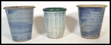 A group of three large stone garden planter pots to include a pair of larger planters and a