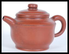 An early 20th Century Chinese Yixing brown clay teapot having four impressed character marks to base