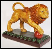A majolica ceramic figurine depicting the Medici lion raised on naturalistic plinth base decorated