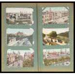 An early 20th Century collection of postcards contained within a red postcard album to include