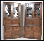 A pair of Jaycee bookcase / cocktail cabinets, two lead glazed doors over linenfold panelled fall