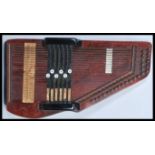 A 20th Century 'Chord Harp' auto harp having five chord options on a stained dark wood base.