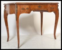 An early 20th Century French Kingswood writing table desk raised on carved cabriole legs with ormolu