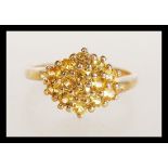 A hallmarked 9ct gold cluster ring set with 14 yellow sapphires. Hallmarked Birmingham. Weight 2.9g.