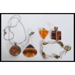 A selection of silver and amber type necklaces and pendants to include a pendant with an oval