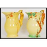 A pair of early 20th Century Burleigh Ware Art Deco water jugs having relief squirrel handles and