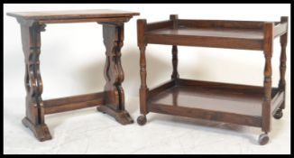 A set of early 20th century oak nest of occasional tables being raised on carved lyre shaped