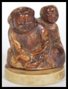 A 19th Century Japanese Meiji period carved lacquered / stained ivory netsuke depicting two figures.