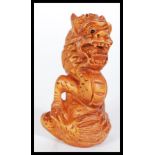 A 20th Century carved Japanese netsuke in the form of a dragon being signed to base. Measures 6 cm