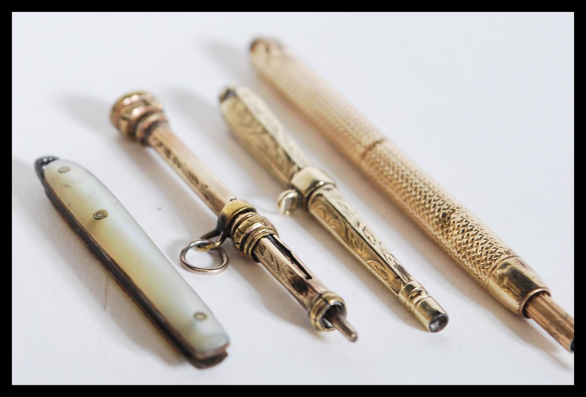 A group of three yellow metal propelling pencils along with a miniature mother of pearl pen fruit - Bild 2 aus 4