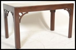 A mahogany coffee table with marble top raised on square supports with carved and pierced fret