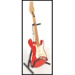 An electric six string Peavey Predator stratocaster style guitar, red body with white flash together