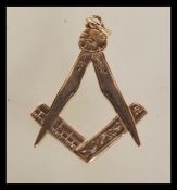 A 9ct gold pendant in the form of a masonic symbol with engraved decoration. Total weight 3.6g.