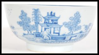 An 18th Century Chinese blue and white bowl having hand painted decoration depicting buildings,