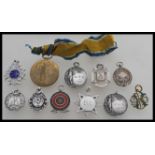 A group of nine silver hallmarked pocket watch albert chain fob medals along with a brass and enamel