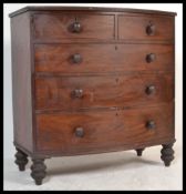 A Victorian mahogany large bow front chest of drawers being raised on tall bun feet with 2 short