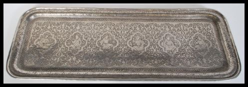 A 20th Century silver white metal tray of narrow proportions having Indian engraving featuring