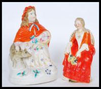 Two 19th Century ceramic figures to include a seated lady with a dog and another seated lady with