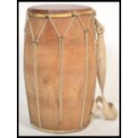 A vintage early 20th Century North Indian large Dholak drum of wooden construction with hide drum