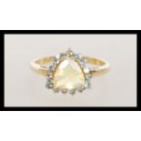 A hallmarked 9ct / 10K stamped gold ring having a central faceted opal stone with a halo of green