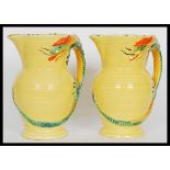 A pair of early 20th Century Burleigh Ware Art Deco water jugs having relief dragon handles. Stamped