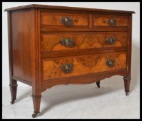An early 20th Century Edwardian walnut cottage two over two chest of drawers raised on tapering legs