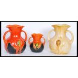 A group of three early 20th Century twin handled vases of bulbous form having flared rims,