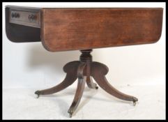 A 19th Century Regency mahogany sofa table desk being raised on splayed reeded leg base with brass