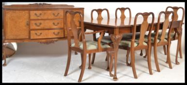 A 20th Century burr walnut dining suite consisting of a an extendable dining table raised on