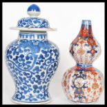 Two small oriental vases to include a lidded baluster vase having painted blue foliate patterning