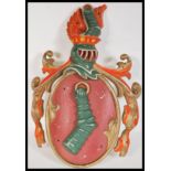 An antique style cast metal Armorial coat of arms / Heraldic crest depicting an embowed arm in armor