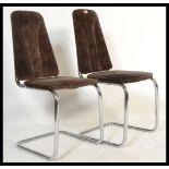 A pair of retro 20th Century cantilever dining chairs, raised on chrome supports and upholstered