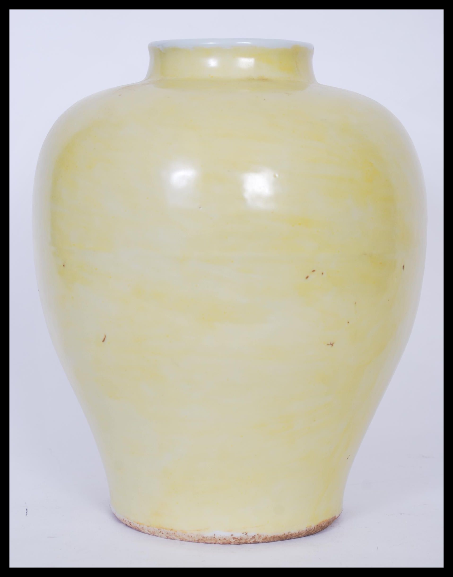 A Chinese monochrome baluster vase of globular squat form having famille Jaune decoration with short