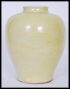 A Chinese monochrome baluster vase of globular squat form having famille Jaune decoration with short