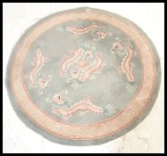 A 20th Century Chinese floor carpet rug of circular form having a teal ground with dragon